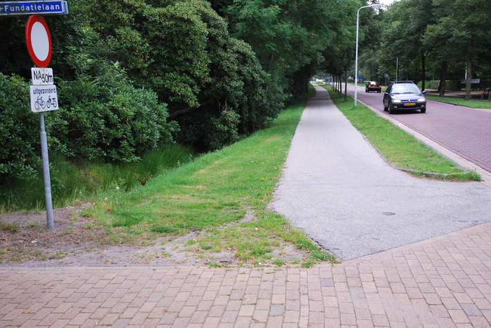 een straat met auto's en waarschuwingsbord